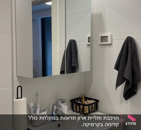 מראה עם תאורה, כיור וברז בחדר אמבטיה
